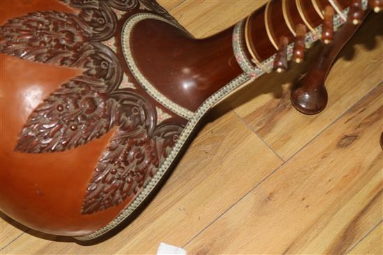 An Indian carved hardwood and decorated sitar 126cm